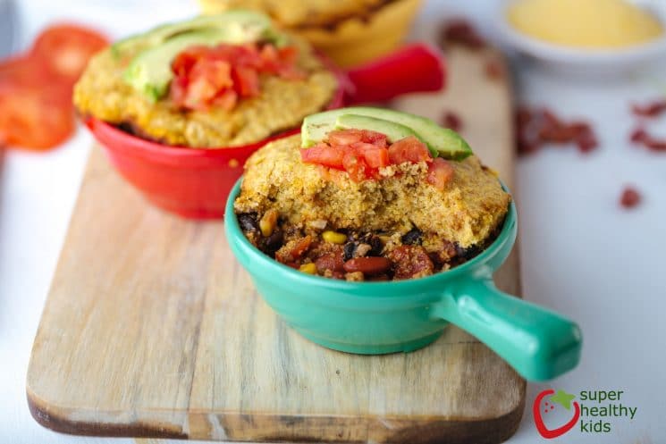 bean and cornmeal casserole in colorful individual serving dishes on a wooden serving board