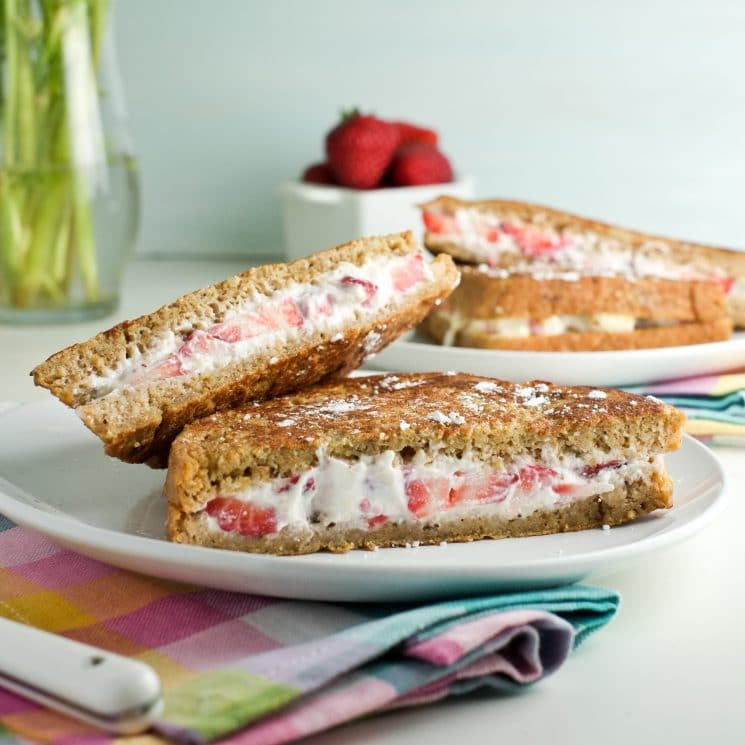 French toast filled with cream cheese and strawberries served on a white plate with a colorful cloth napkin