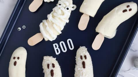 halloween banana pops on a dark baking sheet