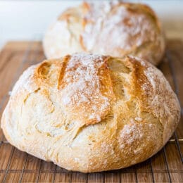 Two loaves of rustic round loaves of artisan bread on cooling racks