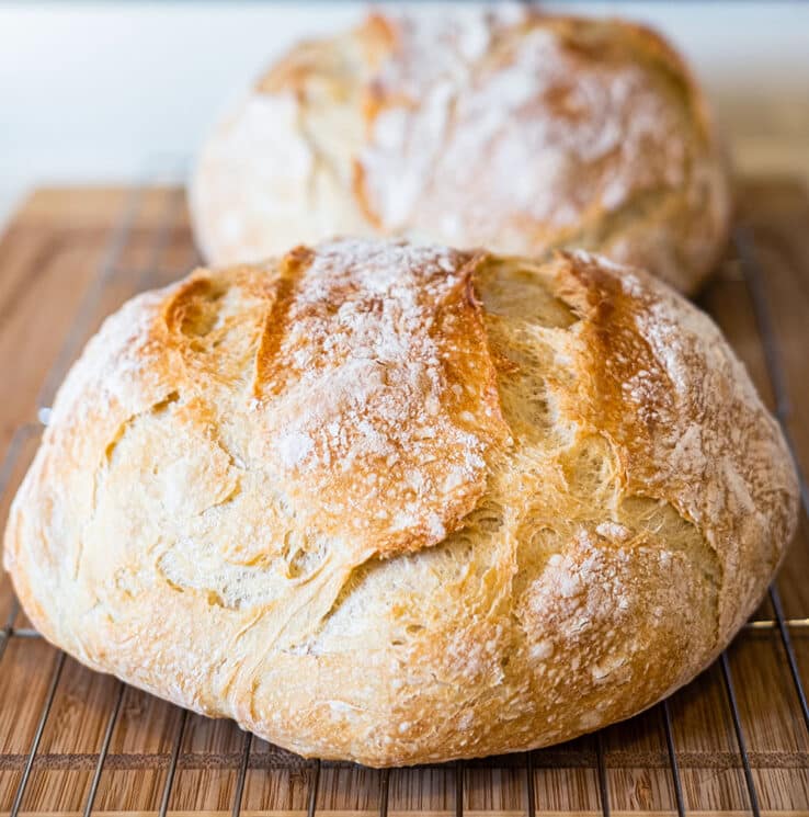 Easy Homemade Artisan Bread Recipe 2 Two loaves of rustic round loaves of artisan bread on cooling racks