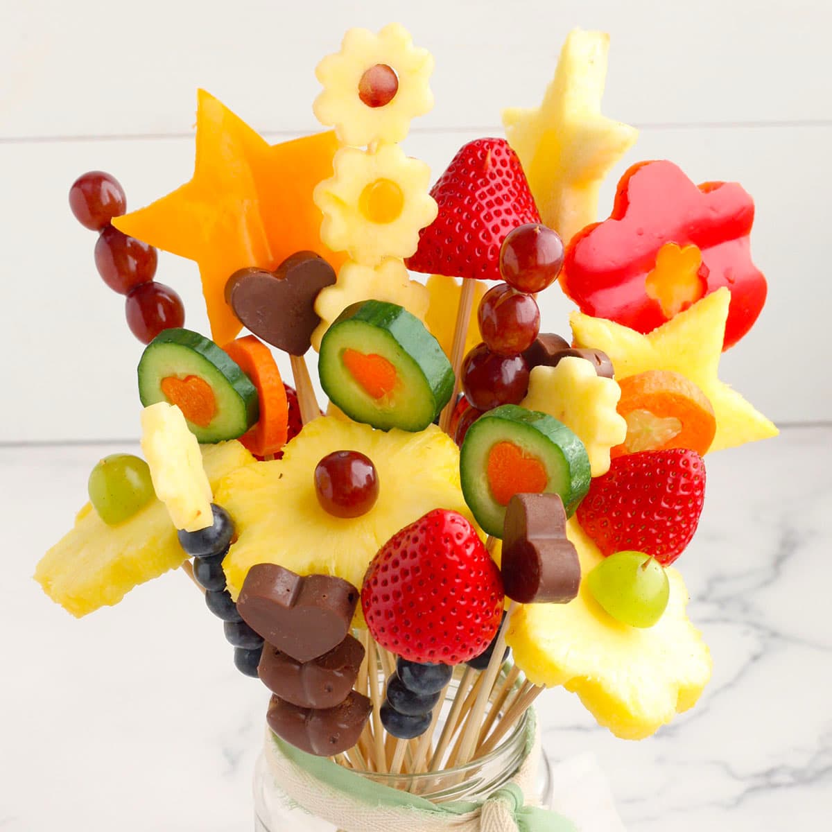 edible bouquet with fruit and veggies in a glass mason jar