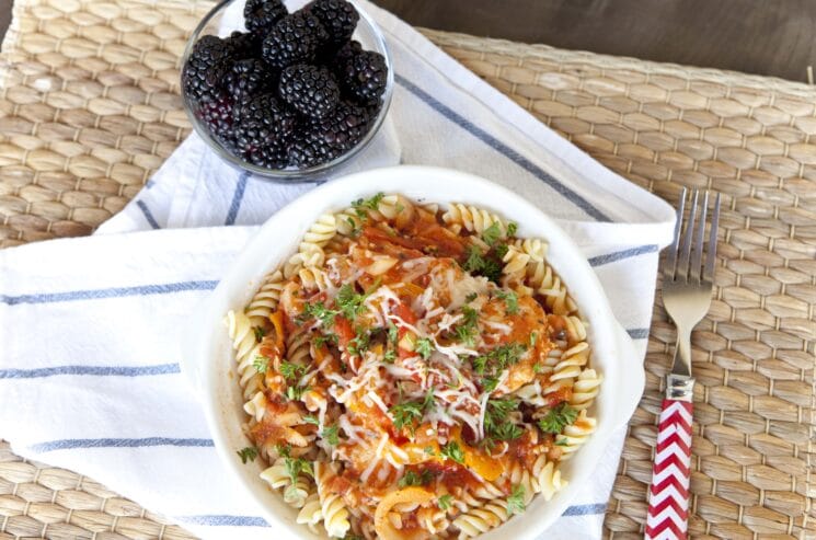 plato de pasta deliciosa con salsa y moras al lado