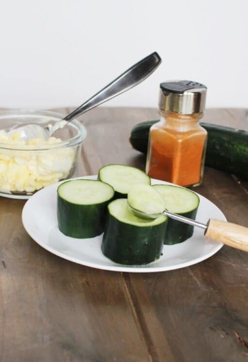 Scooping out the middle of a cucumber for cucumber cups. 