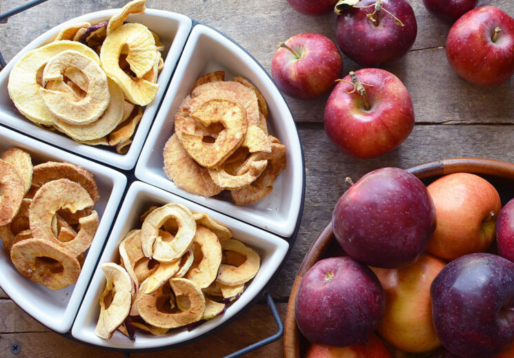 Cinnamon Sugar Dried apples in a white dish with red apples in the background