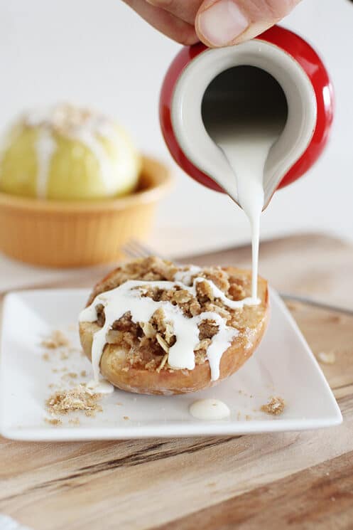 Pouring cream over a baked apple