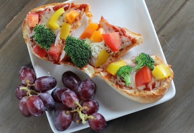 french bread pizza topped with fresh veggies and served with grapes