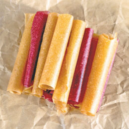 Homemade Fruit Roll-Ups (No Dehydrator Needed) 9 homemade fruit roll-ups on parchment paper aerial view