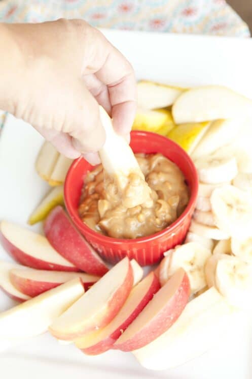 Dipping an apple into healthy peanut butter dip