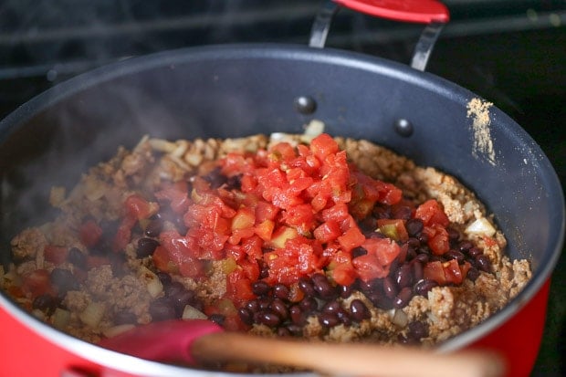 How to make Protein Packed Breakfast Burritos, meat and beans and tomato and onion cooking in a pan