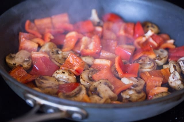 Chicken Pesto Kebabs with bell peppers and mushrooms cooking in a pan