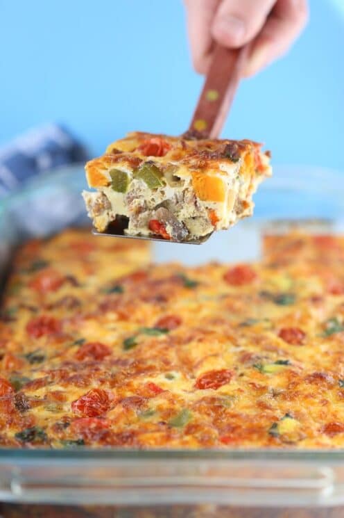 hashbrown casserole in a baking dish with a spatula holding up a slice