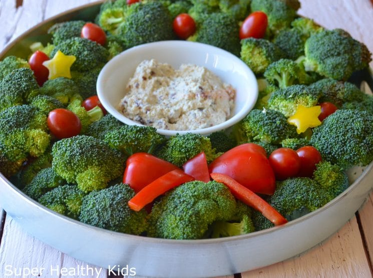 wreath made with broccoli, cherry tomatoes, and a bowl of dip