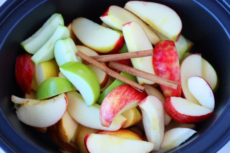 sliced apples with cinnamon sticks in the slow cooker