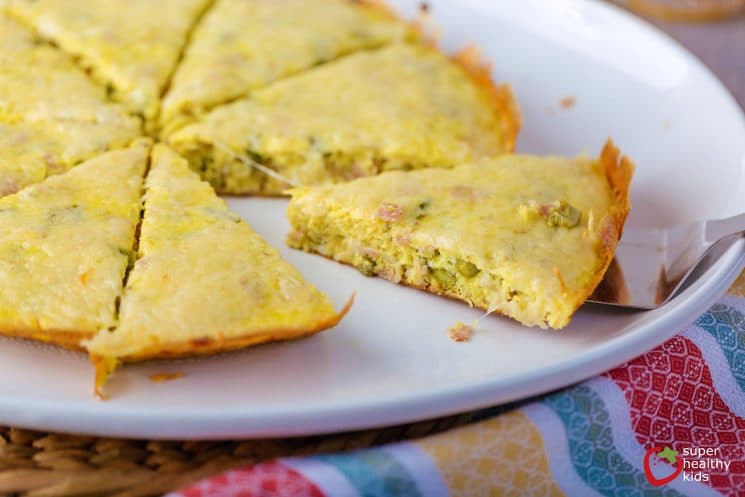 asparagus and cheese frittata cut into wedges on a white plate