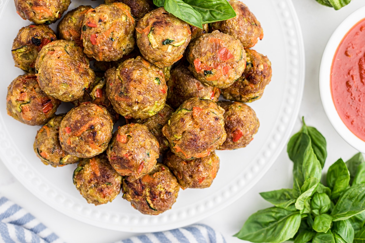 baked chicken meatballs on a white plate with marinara sauce