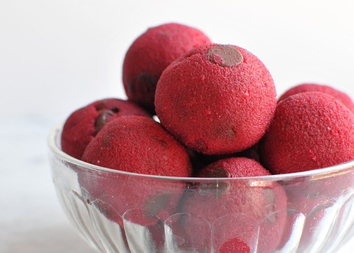 red cookie dough balls in a glass bowl