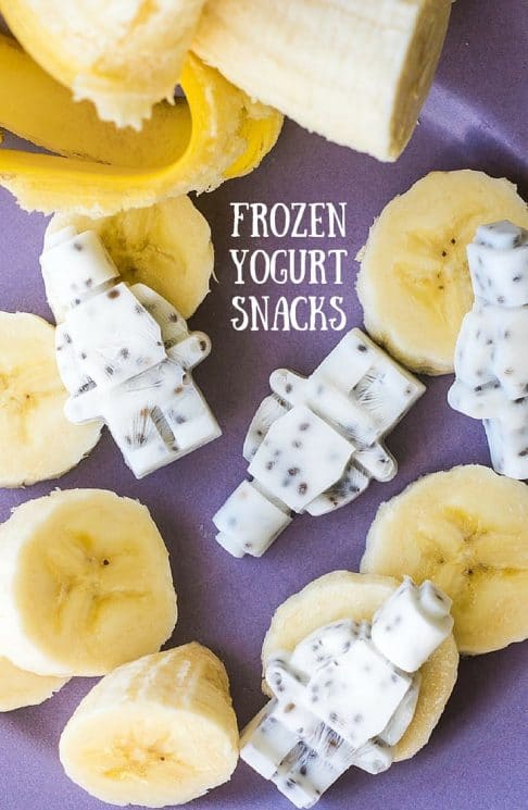 Healthy Frozen Yogurt Snacks made in robot shaped molds, with fresh bananas on the side