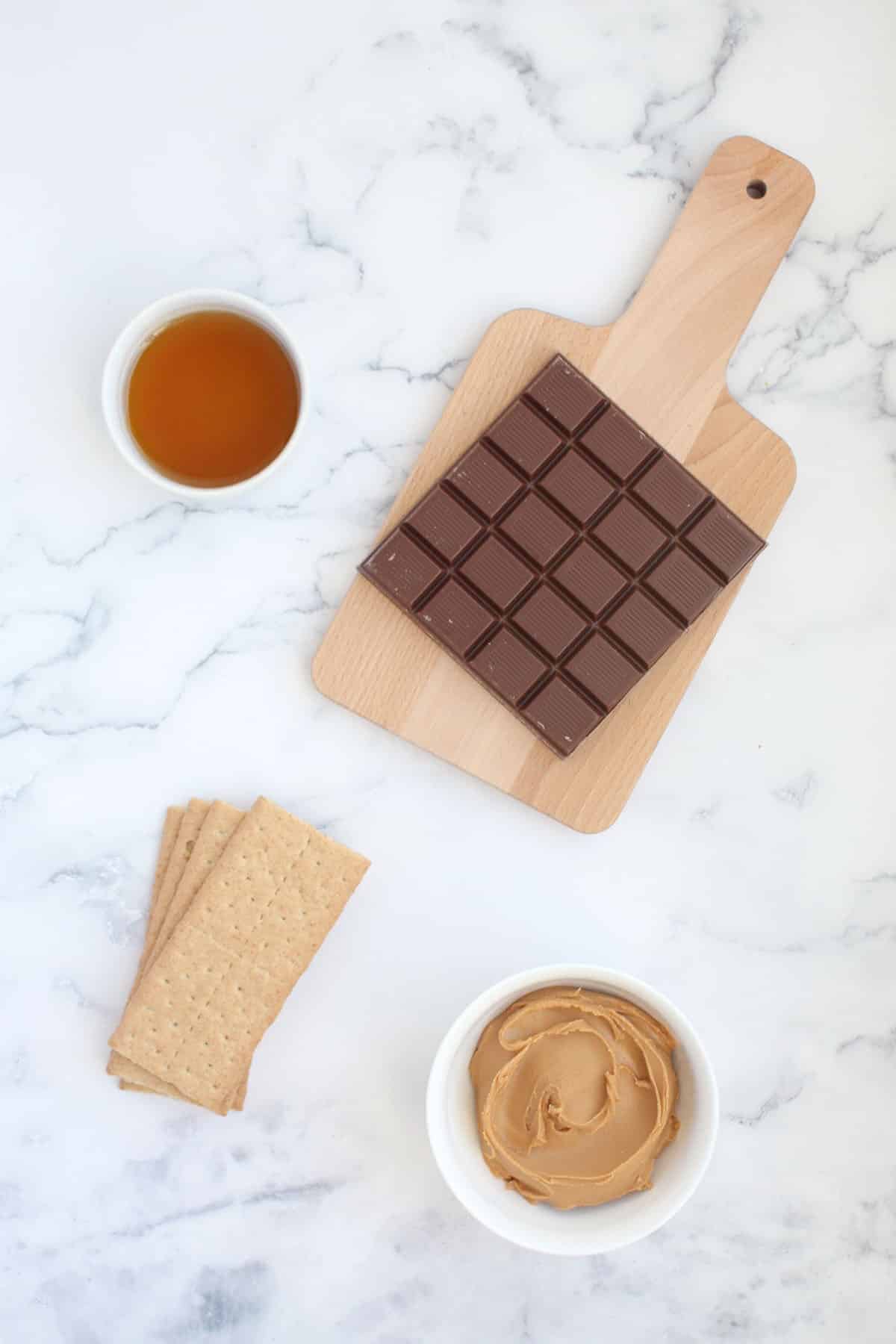 ingredients for peanut butter cup bunnies: chocolate, graham cracker, peanut butter and maple syrup