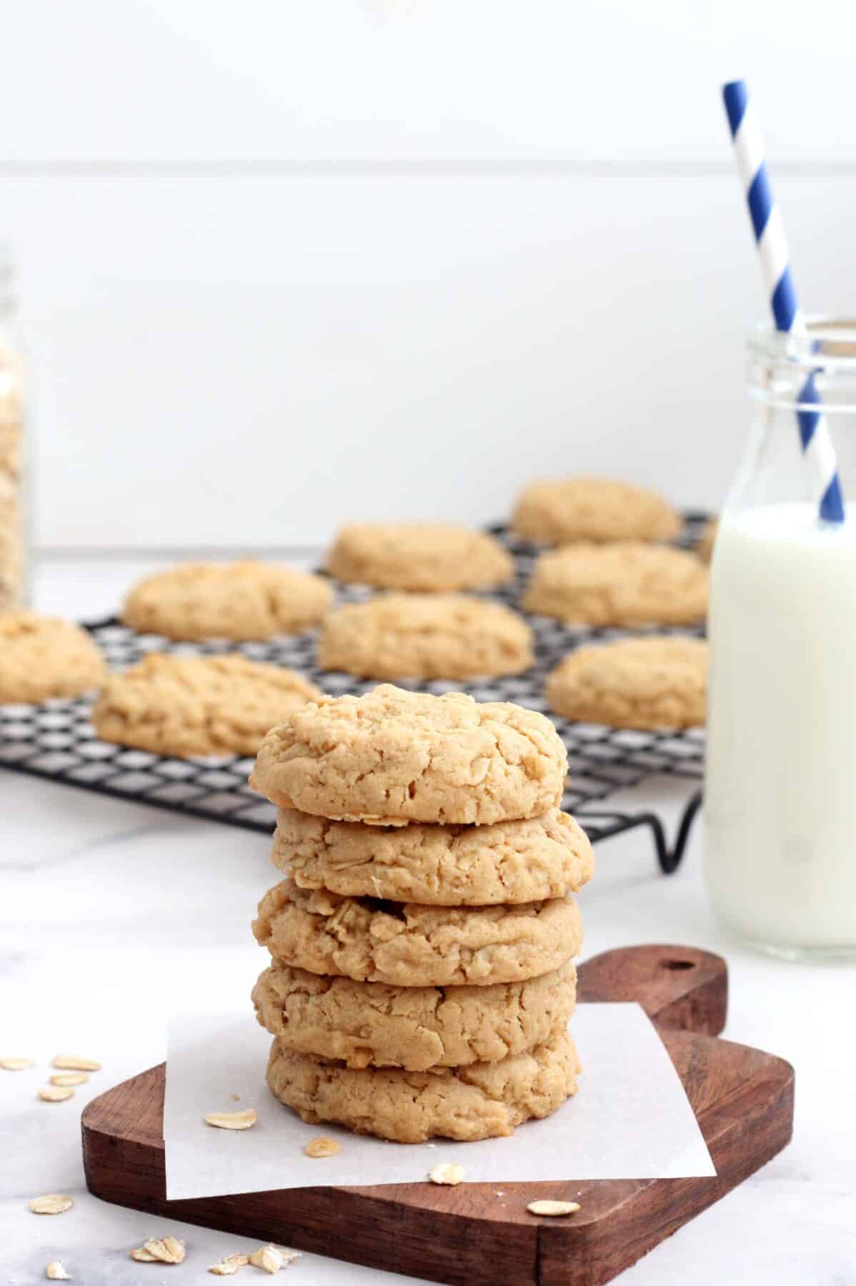 a stack of peanut butter oatmeal cookies with a glass of milk