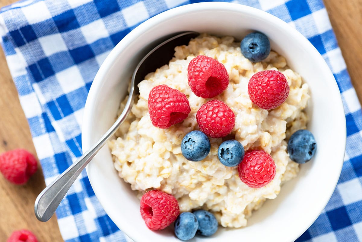 Oatmeal with berries on checkered napkin, top view. Healthy eating, nutrition, healthy lifestyle concept