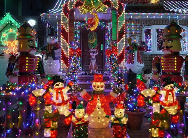 Outdoor Christmas decorations outdoors - snowman and nutcracker illuminate home in Brooklyn, New York