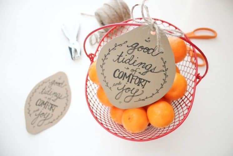 oranges in a red bowl with holiday tag
