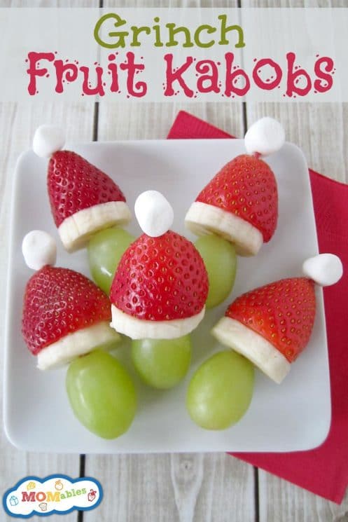 Grinch heads made with a grape, banana slice and strawberry topped with a marshmallow.