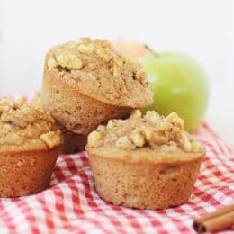 whole wheat applesauce muffins with walnuts on top on a red checkered napkin