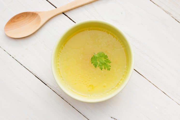 small white bowl with chicken broth in it