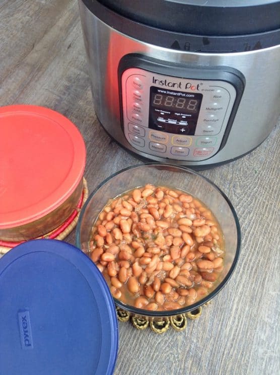 bowl of cooked beans in front of an instant pot