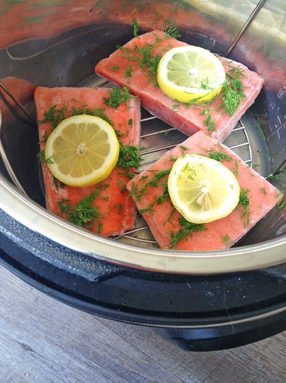 frozen salmon filets in the instant pot with fresh lemon slices and dill