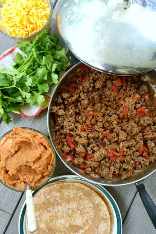 Ingredients for beef and bean burritos read to assemble.