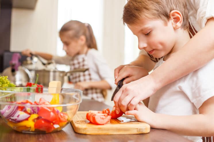 boy learning to slice veggies