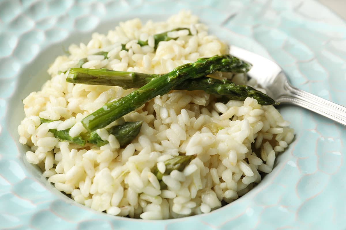 Delicious risotto with asparagus in plate, closeup