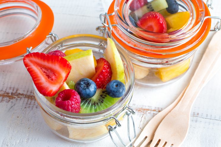 strawberries, raspberries, kiwi, blueberries in jars for a snack on the go