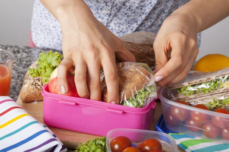 Packing healthy snacks into a pink snack box to take to a theme park