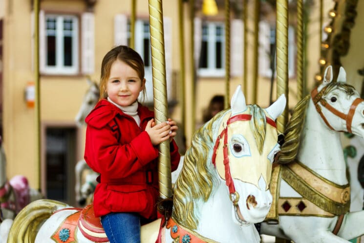 Little girl sitting on a carousel horse