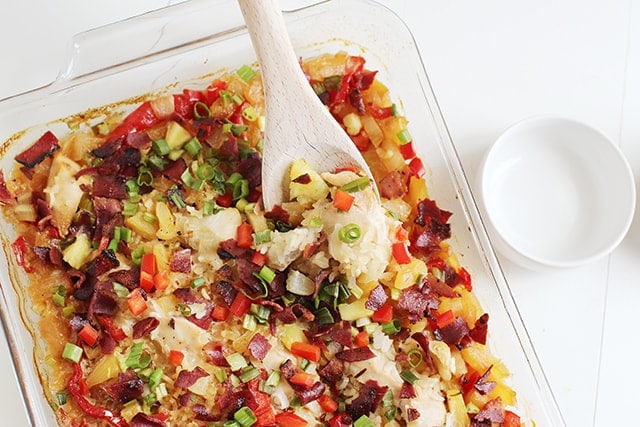Easy Tropical Chicken and Rice Bake in a baking dish with serving spoon