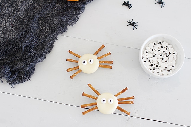 spider bites healthy halloween snack made of baby bell cheese and pretzel sticks for legs