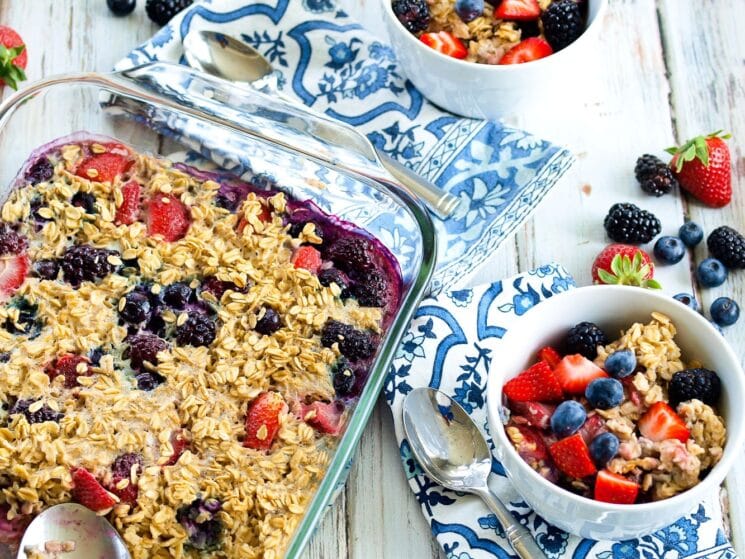 colorful glass dish of baked berry oatmeal on a blue and white country table