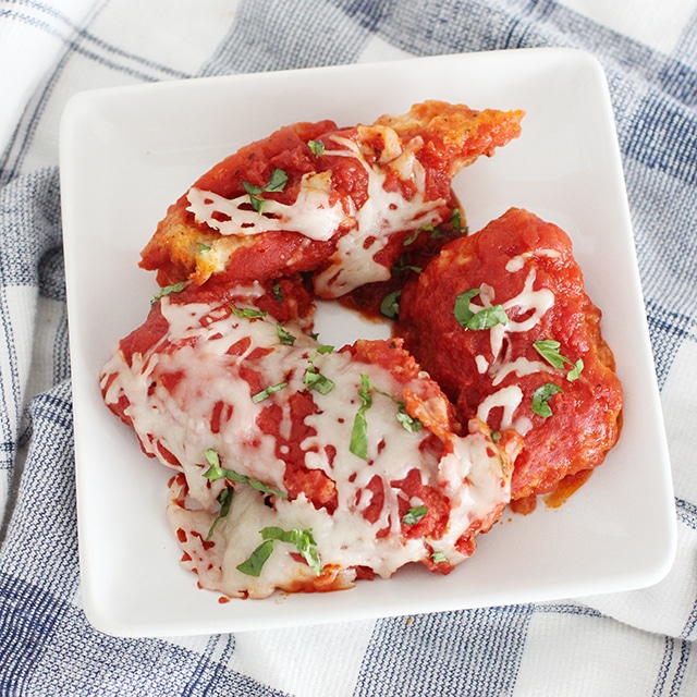 Classic Italian flavor in your Instant Pot! Fall in love with the simplicity of this juicy, tender chicken coated in breading and smothered in a savory tomato sauce and cheese. chicken parmesan on white plate