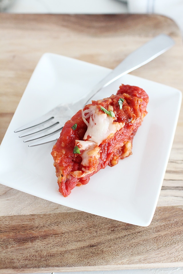 serving chicken Parmesan on white plate with fork