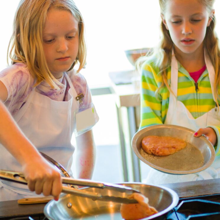 girls learning to cook chicken