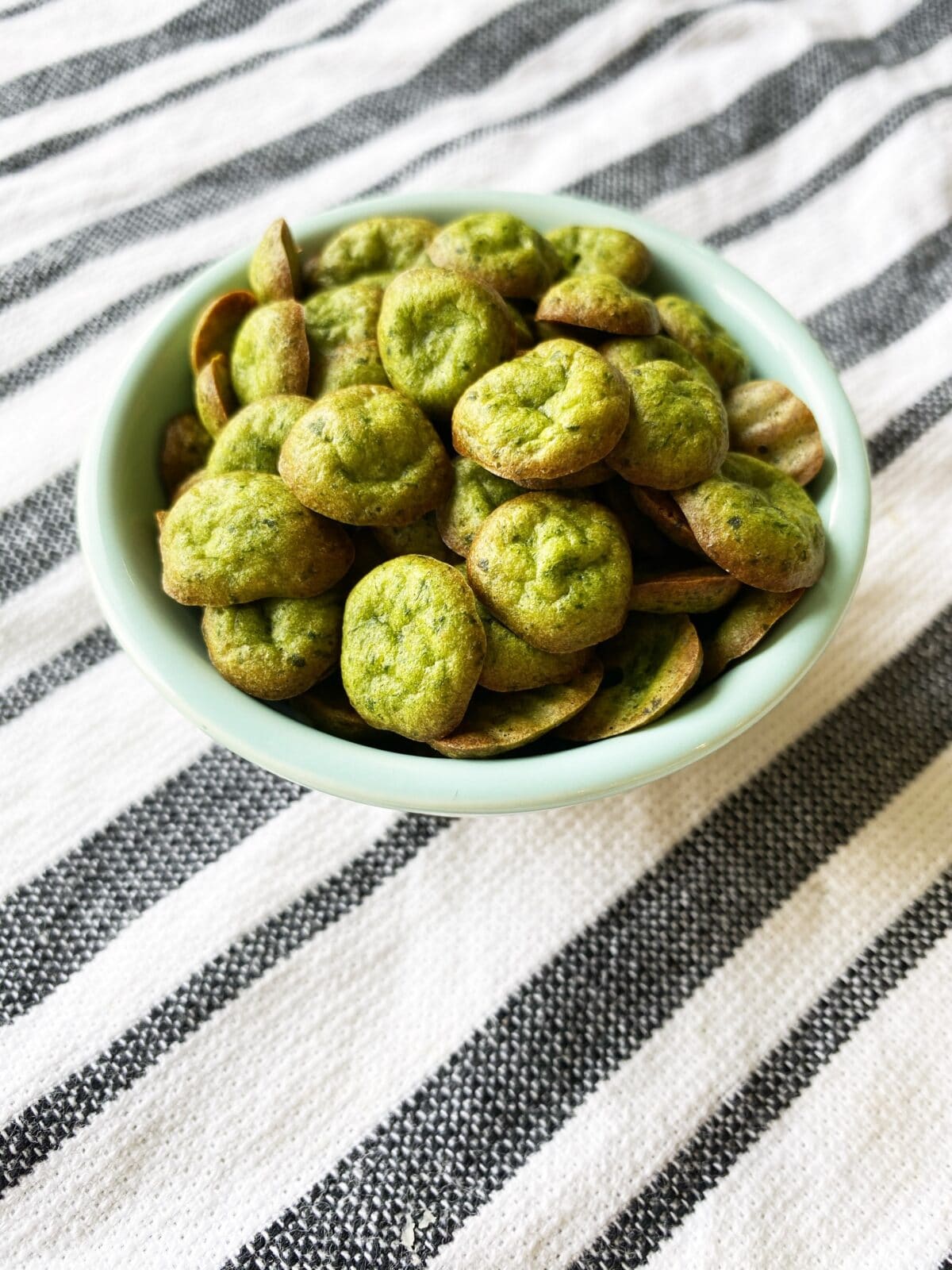 a bowl of homemade baby puffs - green spinach