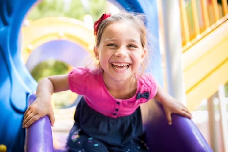 happy girl playing on the slide