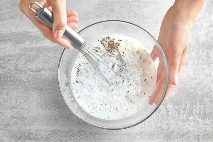 making chia seed pudding by whisking milk and seeds