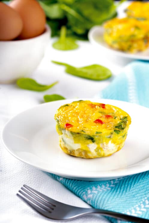 egg muffin on a plate with peppers and spinach