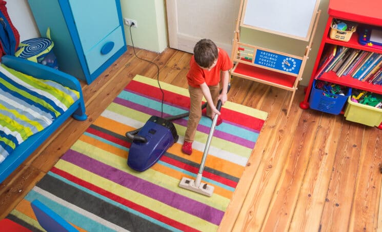 boy vacuuming his room summer chores