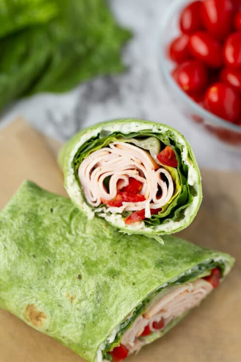 close up tortilla with turkey, lettuce, and tomato